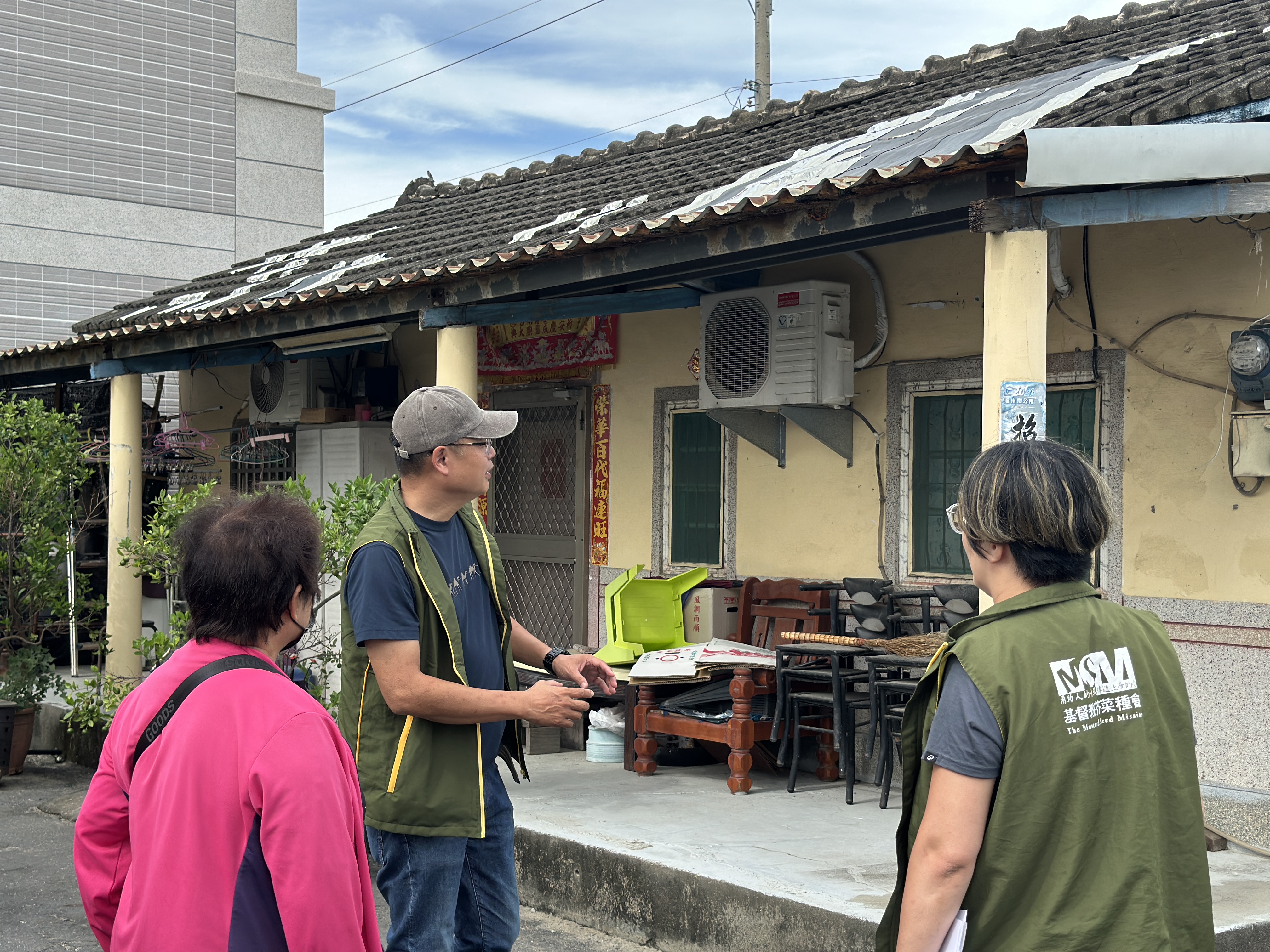 玉蘭阿嬤（左一）家的屋瓦年久失修，儘管多次克難修補，仍難以抵擋風雨侵襲。芥菜種會團隊前往訪視，實地了解屋況並評估後續修繕需求。