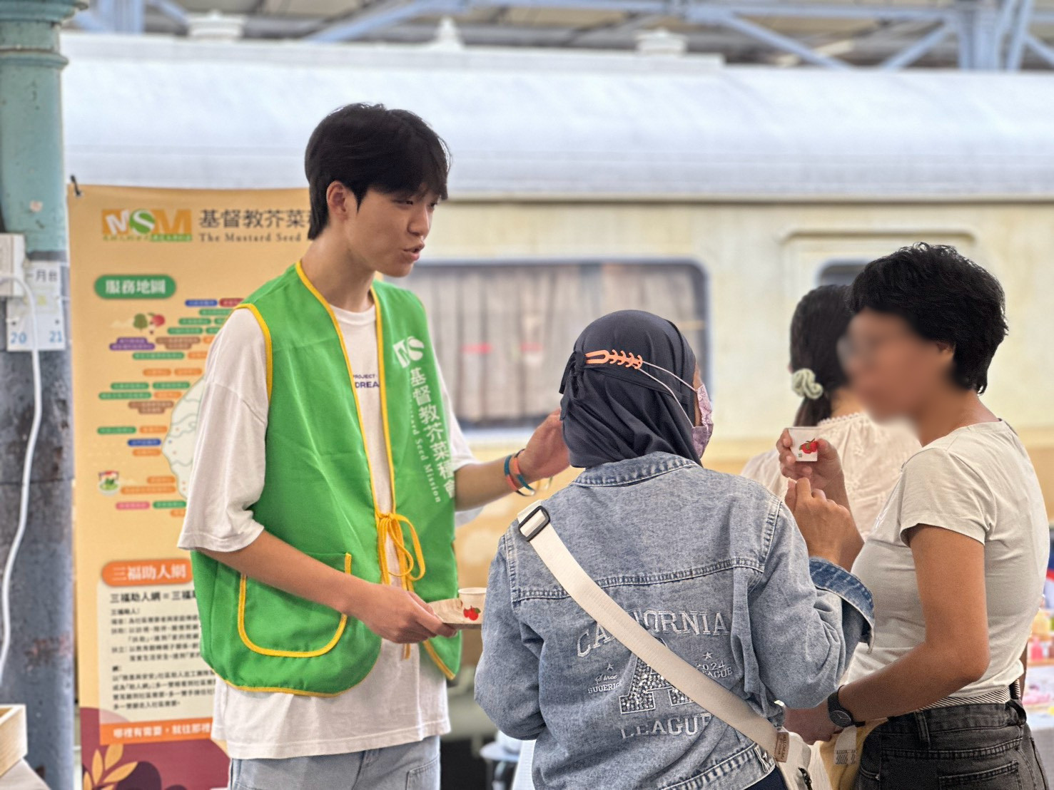 阿德（左1）邀請顧客試喝「習得茶」介紹品牌理念，將培力課程所學化為與人溝通的實際行動。
