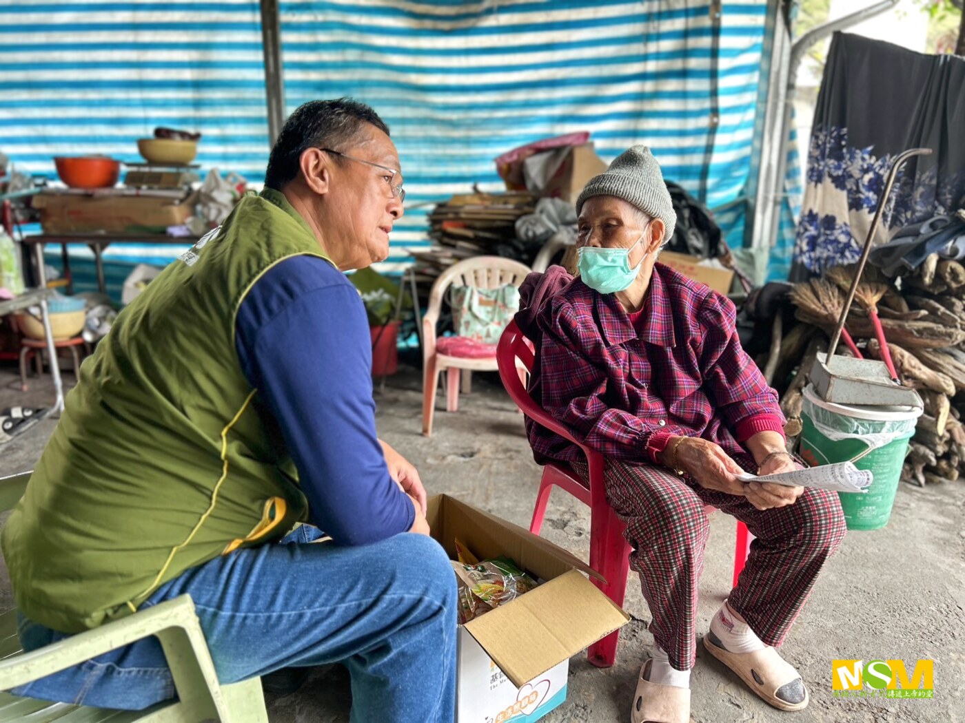 An MSM worker listening to an elder during a home visit in Baliyuan