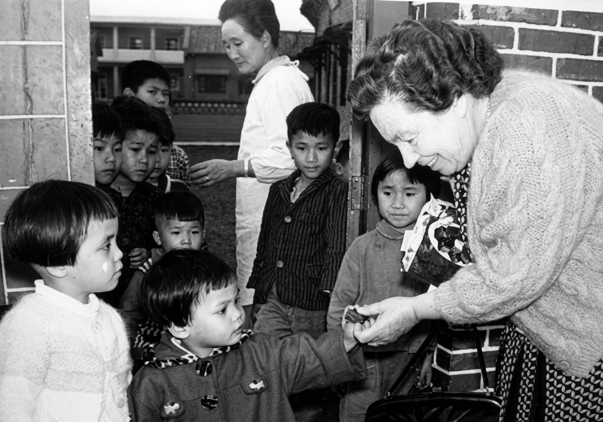 Archival photograph of founder Lillian Dickson with children in Taiwan
