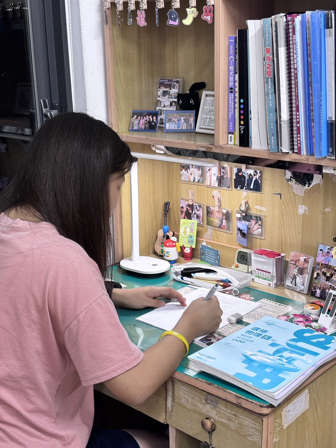 Lynn studying at her desk, photographed from behind to protect her identity