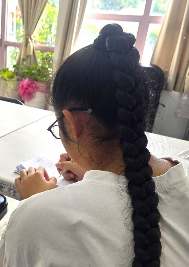 A child writing during a family communication activity, photographed from behind