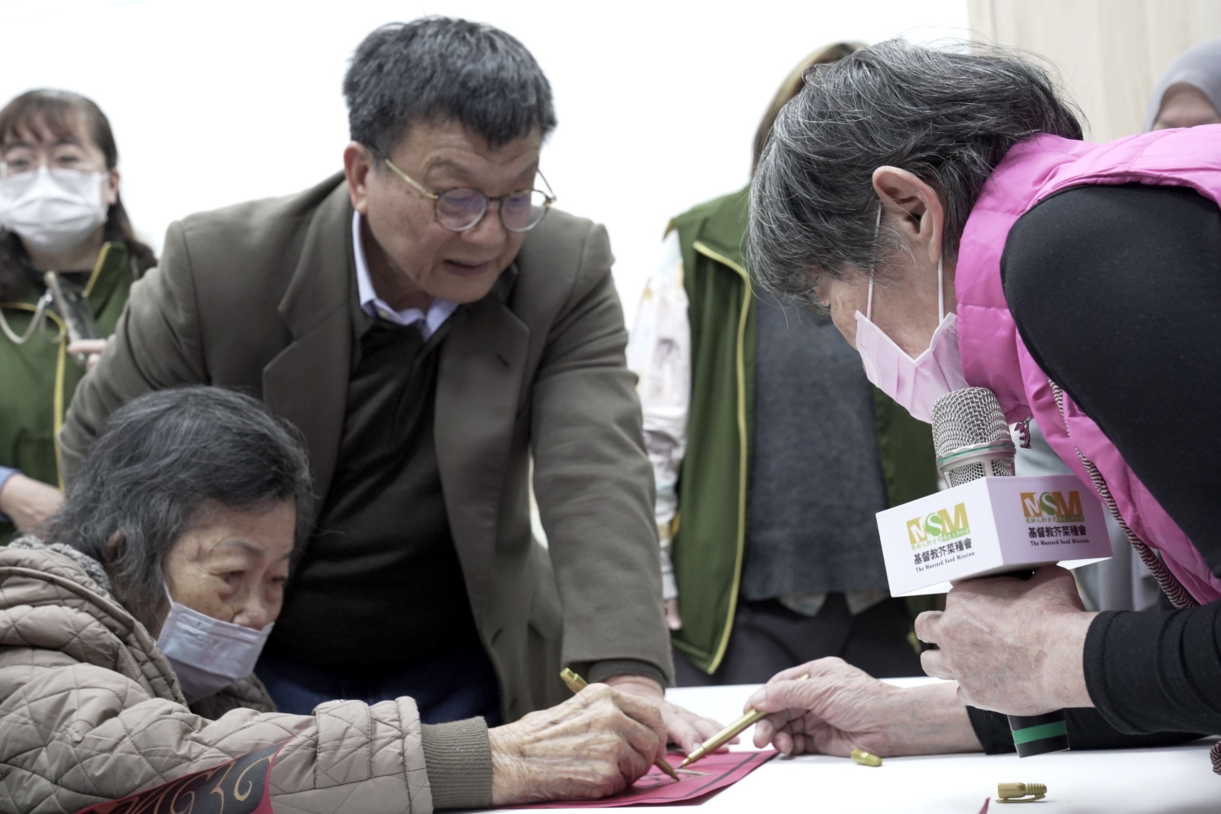 芥菜種會「共學師」(右一)引導五股助人網「樂福學堂」長者描繪年畫迎新春。