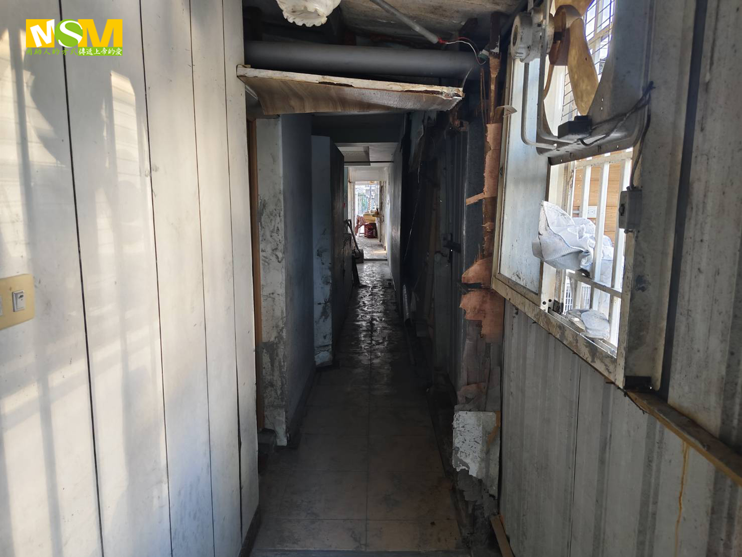 走廊的窗戶與牆壁皆破損不堪。