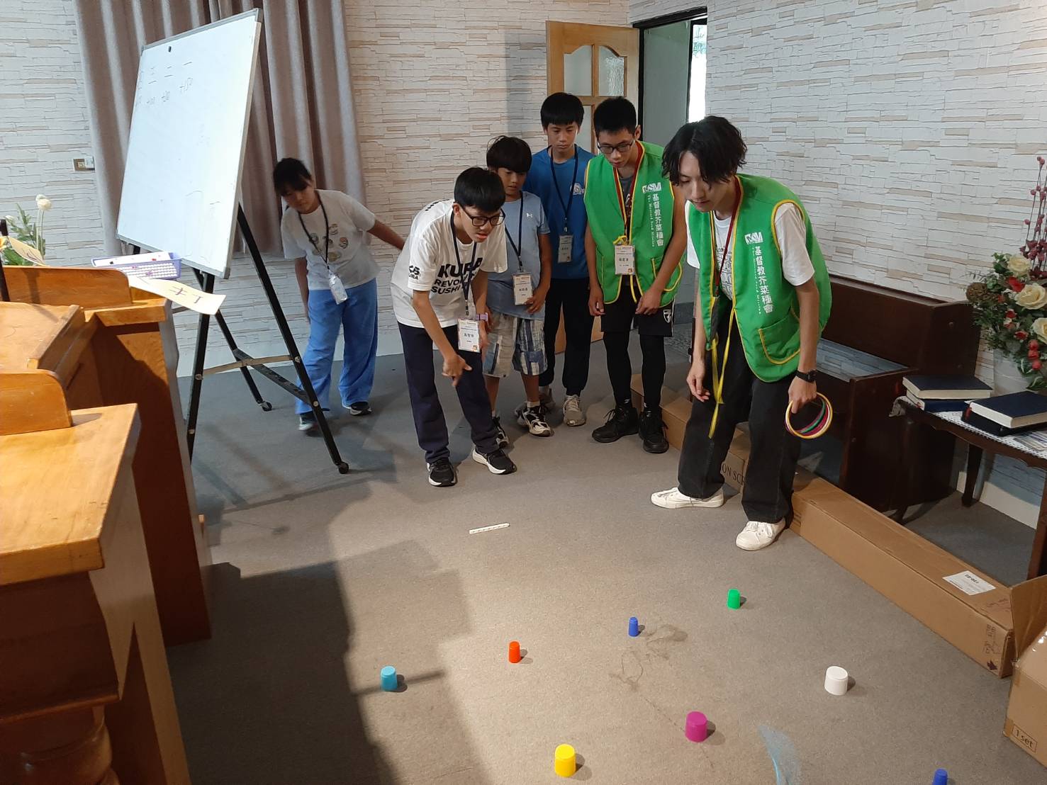 少年之家青年（右二）擔任積木營小隊輔，陪伴孩子在合作與互動中完成挑戰，培養團隊精神。
